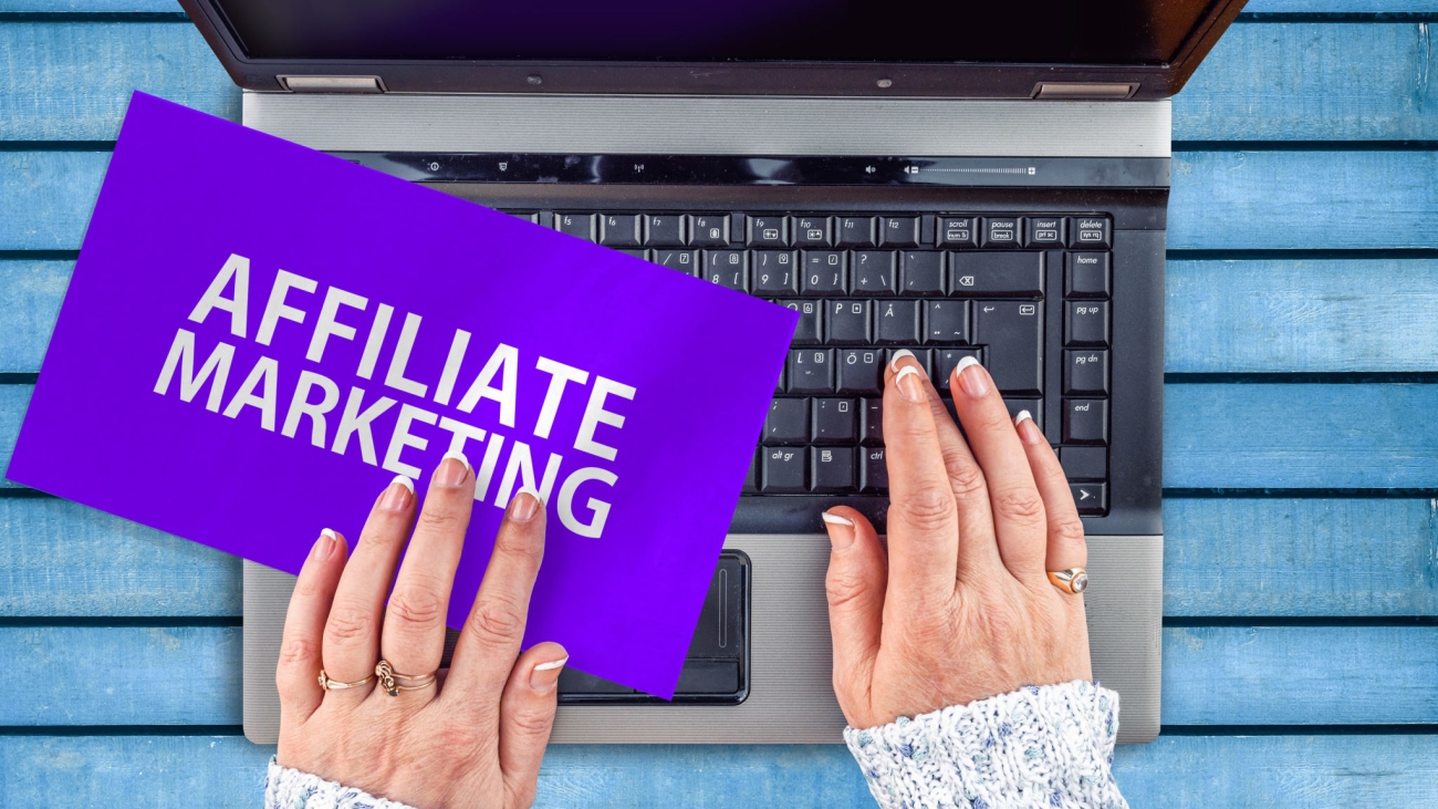 woman hands on laptop and Affiliate marketing words on paper sheet